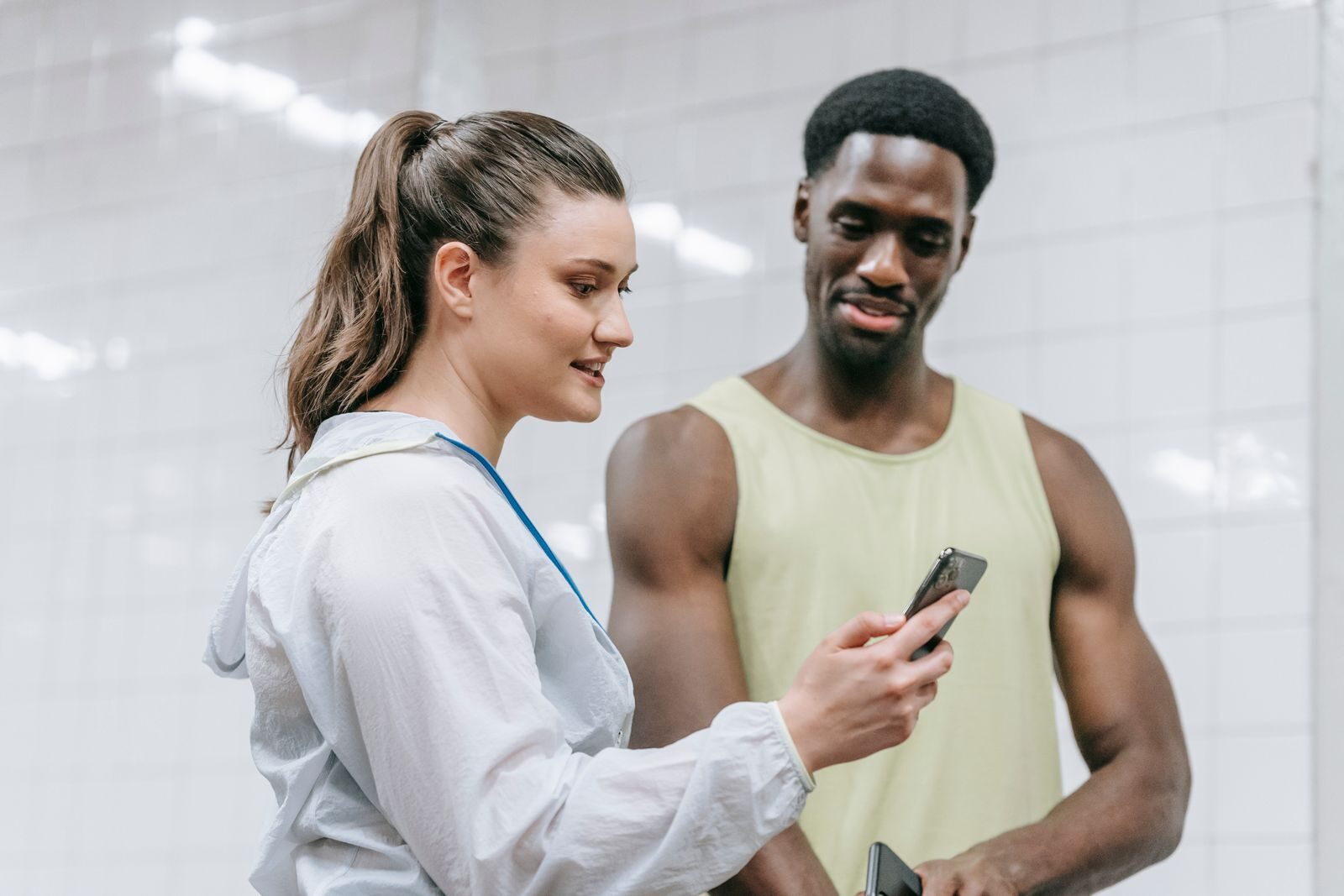 Deux personnes regardent un téléphone dans une salle d'entraînement